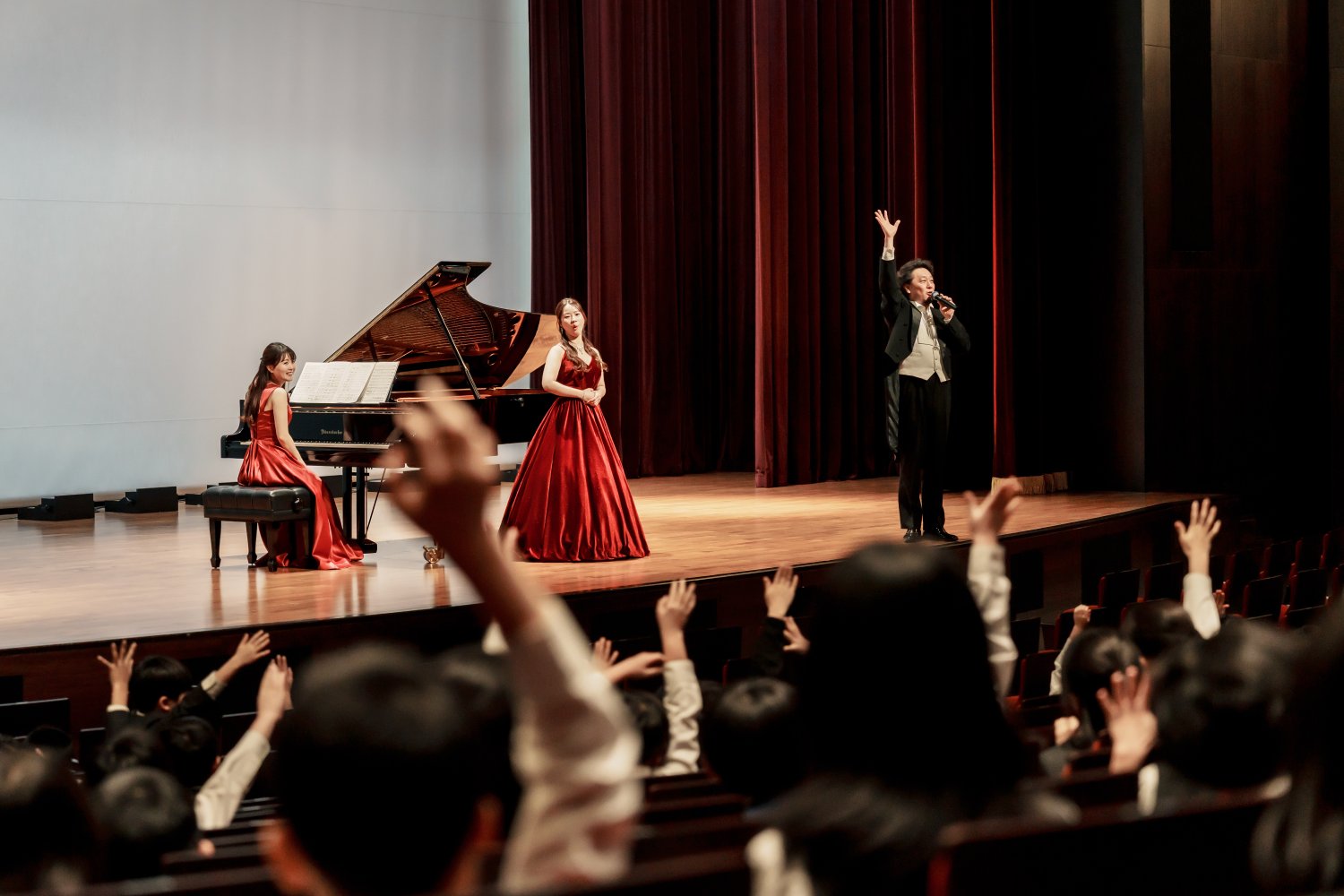 コンサートで答るための挙手をするこどもたちの写真